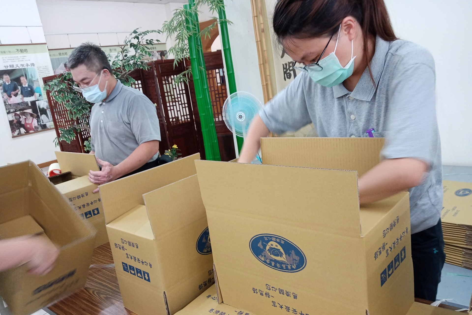 慈濟結合南投縣政府捐贈2062戶弱勢學童家庭暑期安心生活箱、健康蔬果箱，7月9日上午在南投聯絡處進行包裝工作。