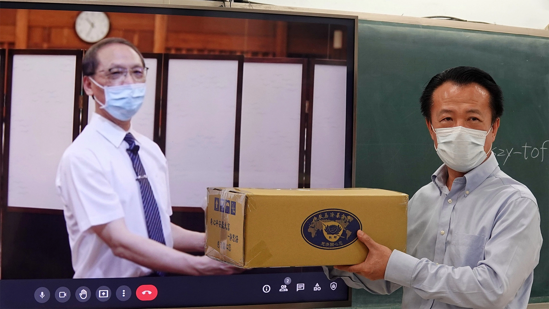 慈濟捐贈嘉義縣政府1500戶弱勢學生家庭暑期安心生活箱、健康蔬果箱,7月15日由慈濟顏博文執行長(左)透過視訊交給翁章梁縣長(右)。
