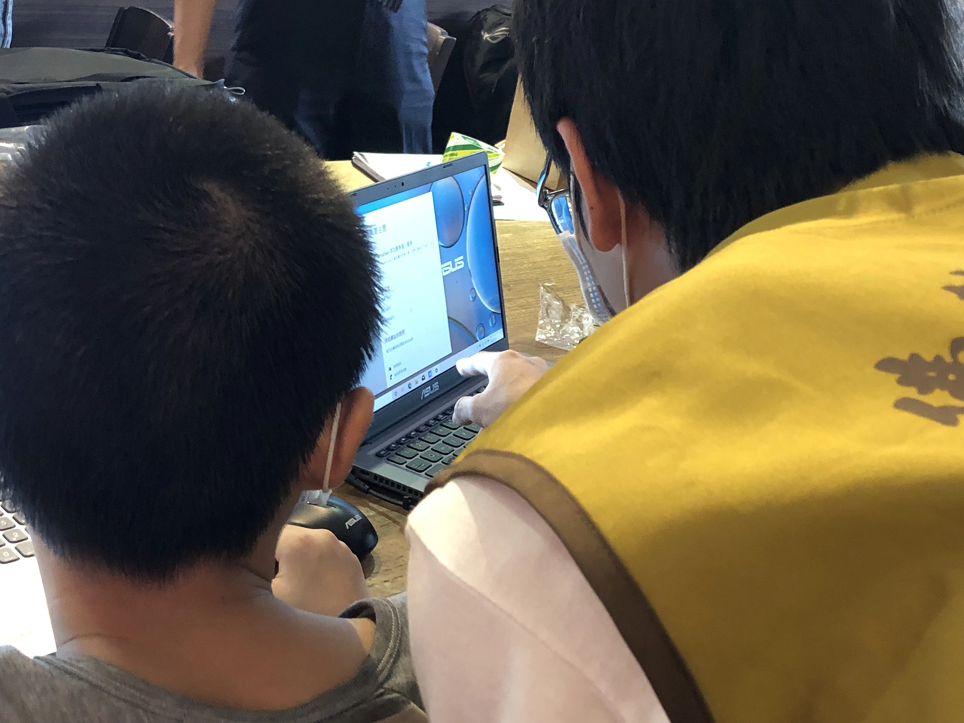 7月30日志工將筆電交給弱勢家庭孩子,並指導使用。