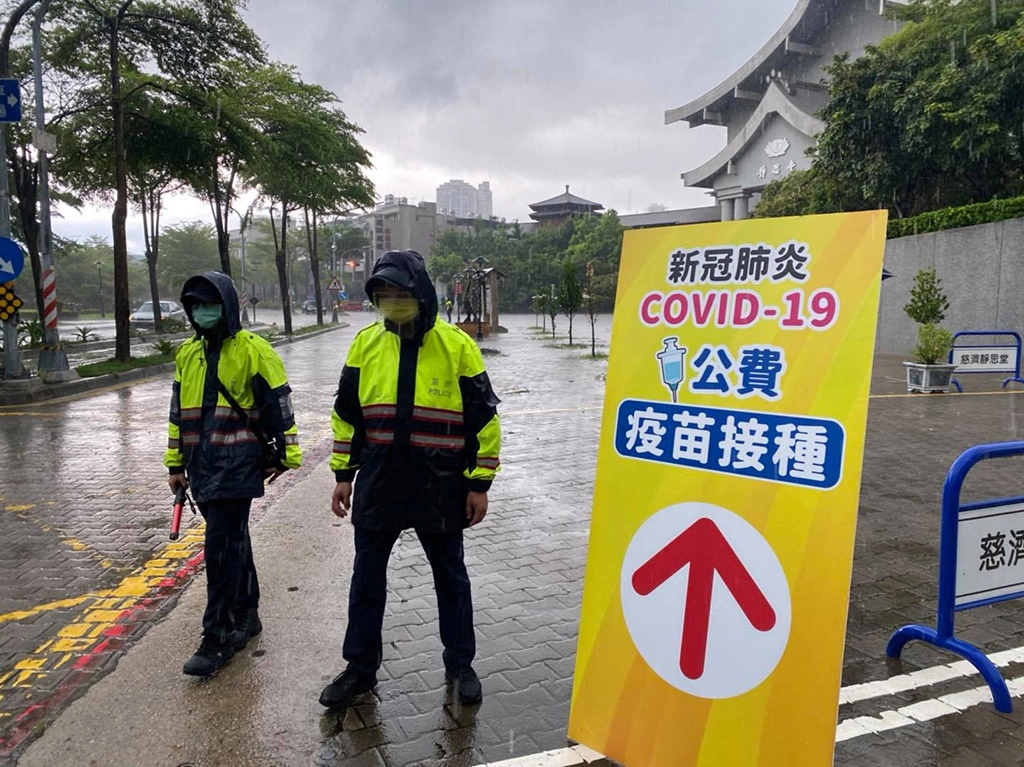 高雄三民二分局員警在高雄靜思堂引導施打疫苗民眾進出動線。