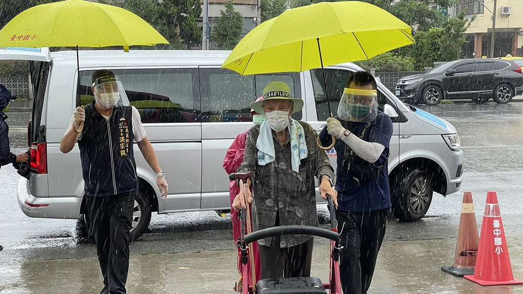 台中市東區快打站工作人員貼心為長者撐傘,減少降雨帶來的不便。