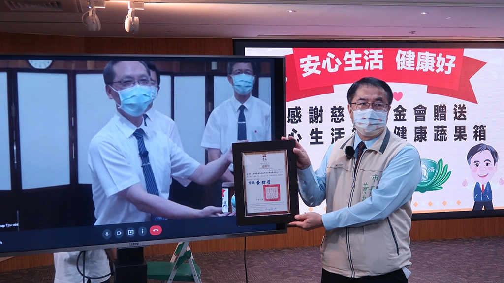 慈濟捐贈台南市政府5880戶弱勢學生家庭暑期「安心生活箱」及「健康蔬果箱」,黃偉哲市長(右)代表致贈感謝狀。(攝影:台南市政府)