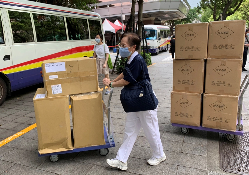 慈濟志工帶來一箱箱防疫物資,提供醫護人員「衣」起「罩」顧的能量。
