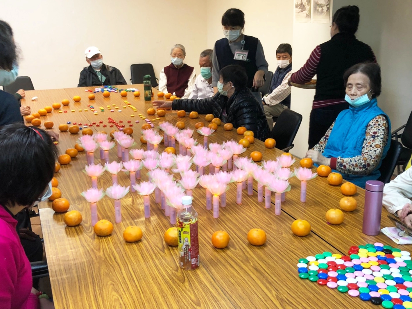 長輩們還以蓮花燈排出吉祥字樣,最後用橘子排出兩顆愛心把平安與吉祥包圍起來,與社區據點活動主軸「戀(練、鏈)幸福」串連起來。