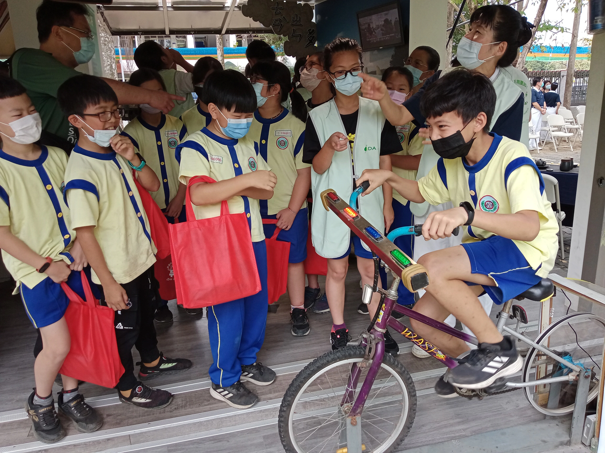 5月4日「慈濟行動環保教育車」於南投縣竹山國小開展,騎腳踏車一小時可產生多少電量?學生賣力踩。(攝影:許昆龍)
