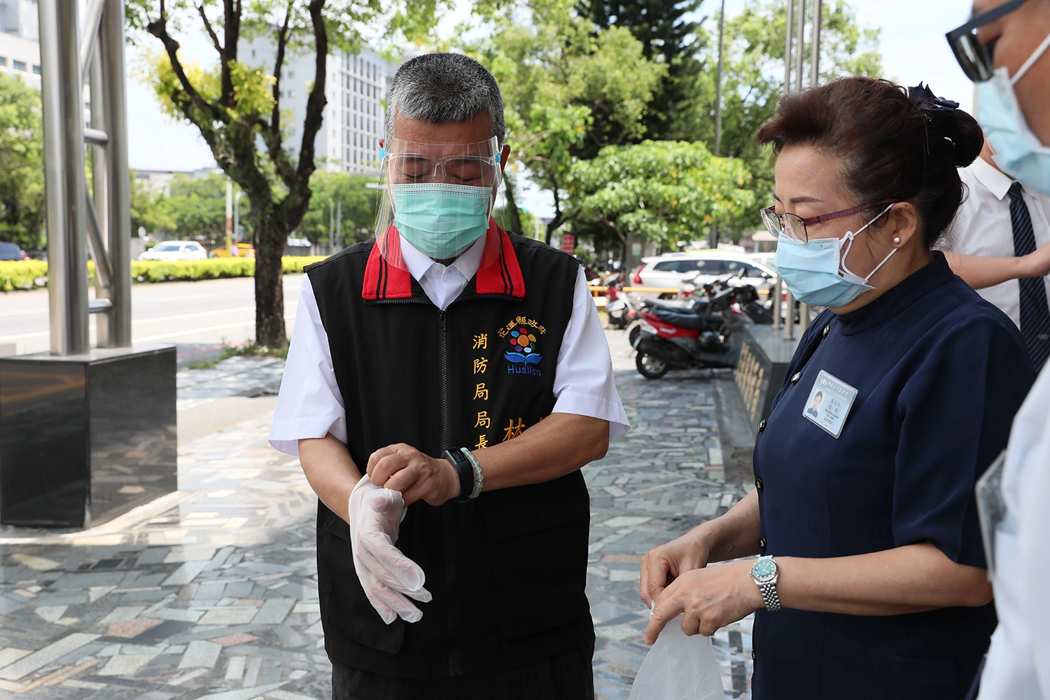 花蓮慈濟志工5月28日前往花蓮縣消防局捐贈防護面罩、PVC手套,由局長試戴確認是否合用。
