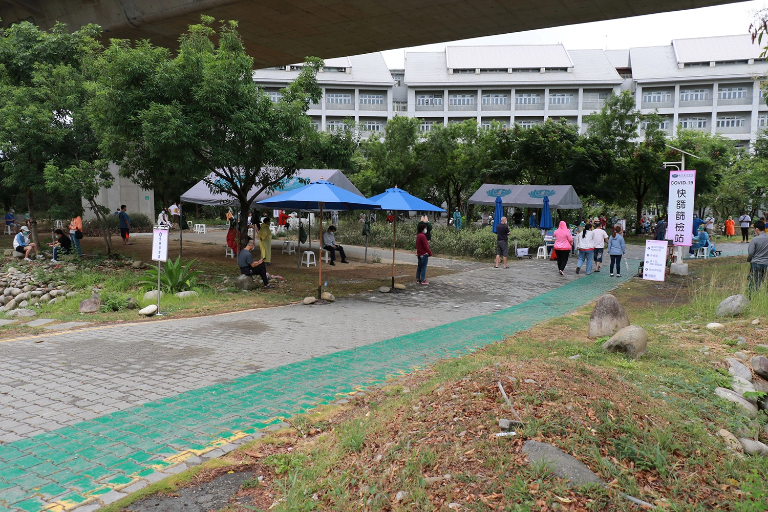 週日上午陣雨降臨,仍有大批民眾來到臺中慈院快篩站篩檢。