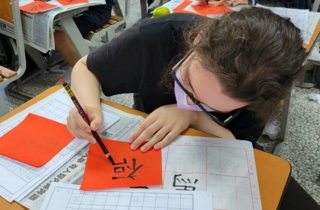 臺南慈中高中部學生指導來自英國成大外籍學生Lauren寫書法,新鮮很有趣。