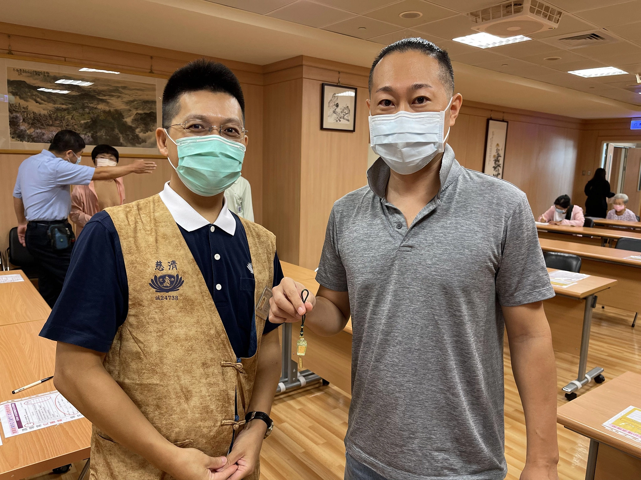 市川先生(右)獲贈靜思祈福心燈吊飾,特地與日語志工劉奕男師兄(左)合影。
