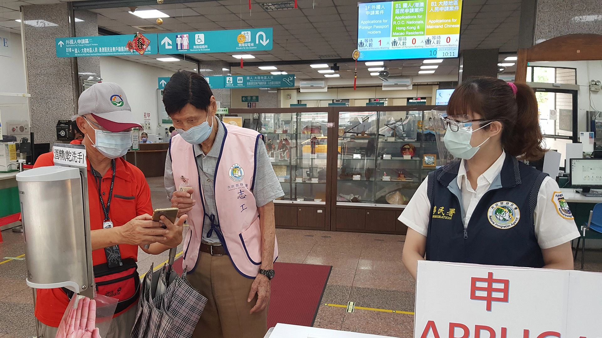 童家祥(中)投入移民署志工行列,以溫暖服務洽公民眾。