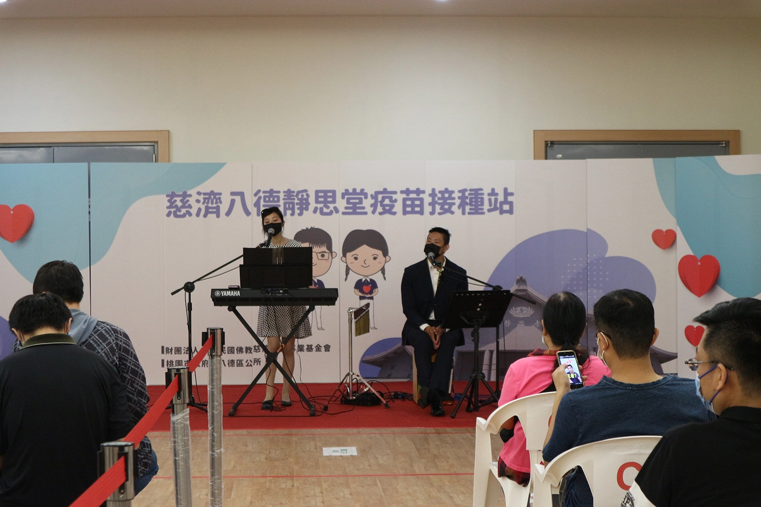 八德靜思堂,今(14號)日進行BNT疫苗第一劑施打,邀請來自北投的「青梅竹馬」(團體名)帶來電子琴彈唱,透過輕快的演唱,讓鄉親能放鬆心情接種疫苗。