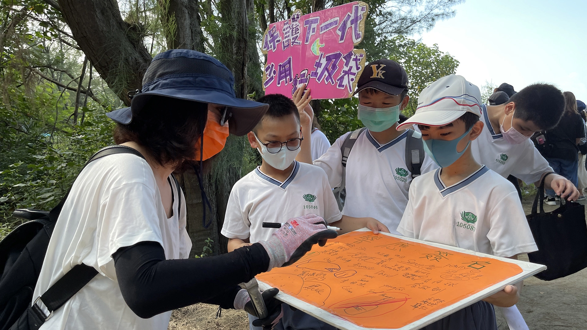 跟沙灘遊客進行減塑宣導,遊客聽得專心