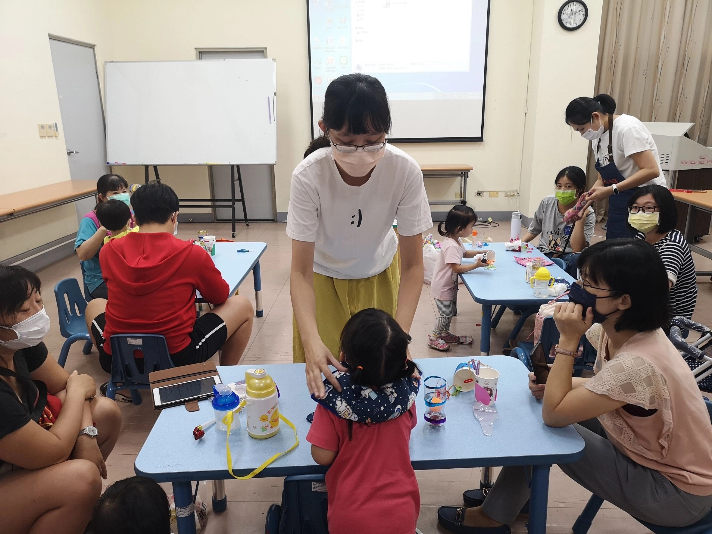 楊立韻老師(中)分享她第一個手作教具重力毯，讓孩子和家長彼此體驗。
