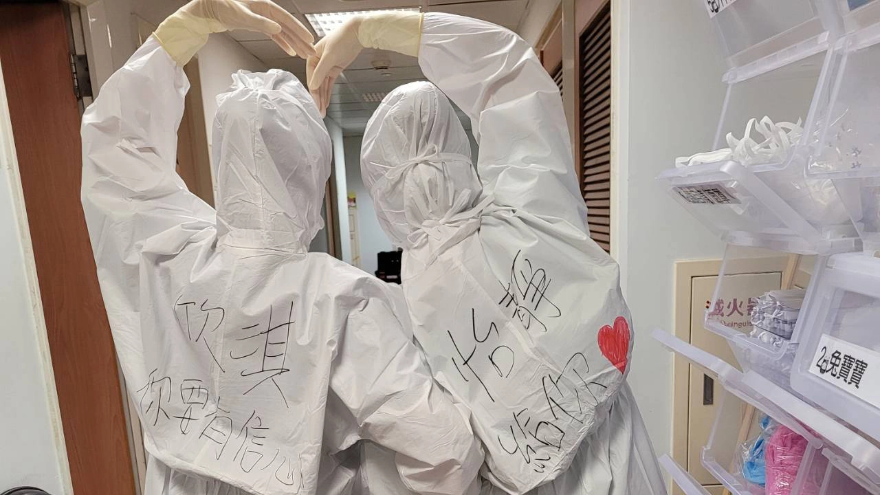 護理師們在隔離衣上畫上愛心,寫下祝福與鼓勵。