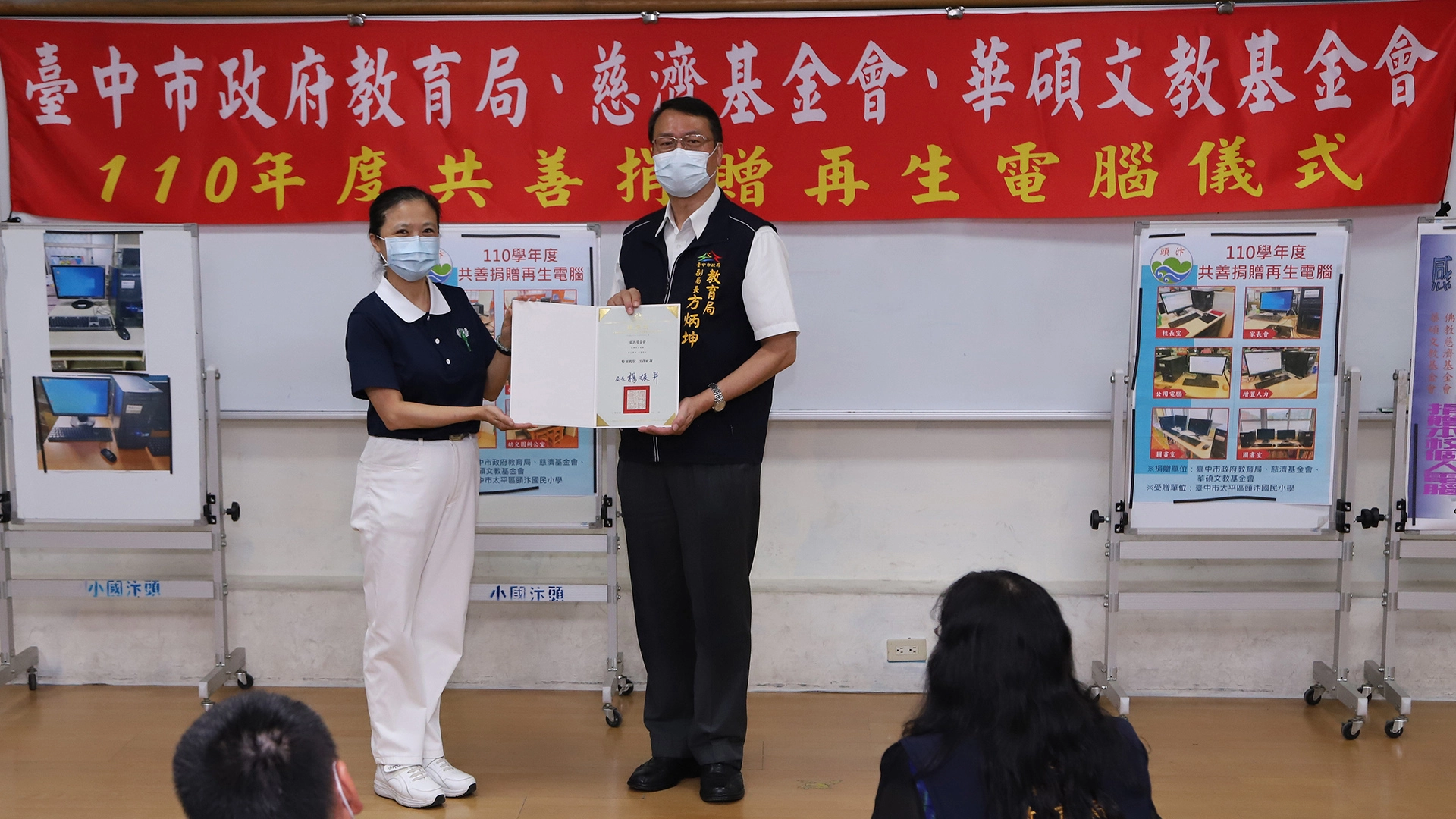 台中市政府教育局方炳坤副局長(右),代表楊振昇局長贈送感謝狀給慈濟基金會,由志工蔣淑麗(左)代表接受。