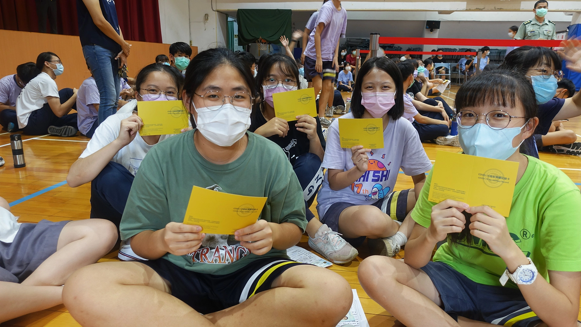 台中市9月23日起為全市高、國中學生進行BNT疫苗第一劑接種作業,同學等候時拿起Covid-19疫苗接種紀錄卡合影。
