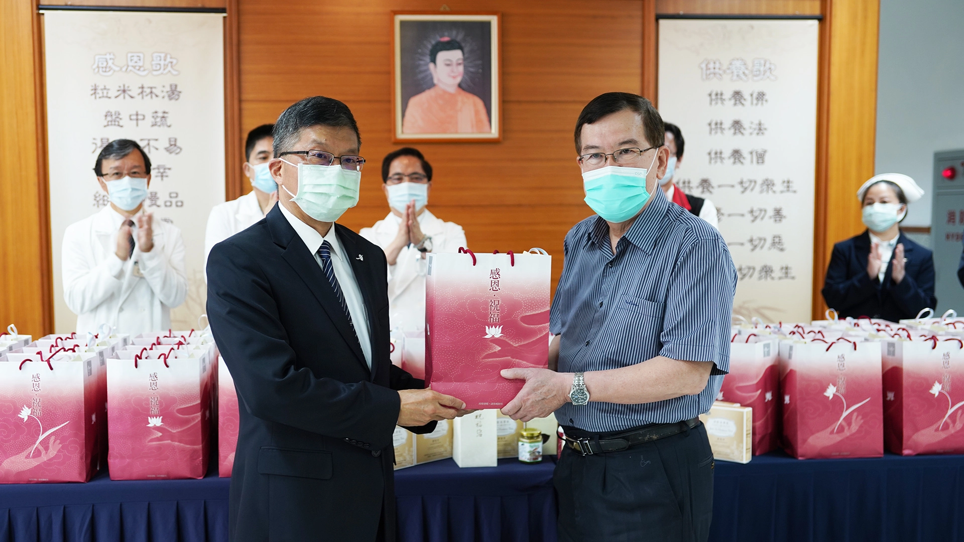 致贈儀式,由慈濟基金會副執行長劉效成(左)與加強型防疫旅館經理林于凱代表。