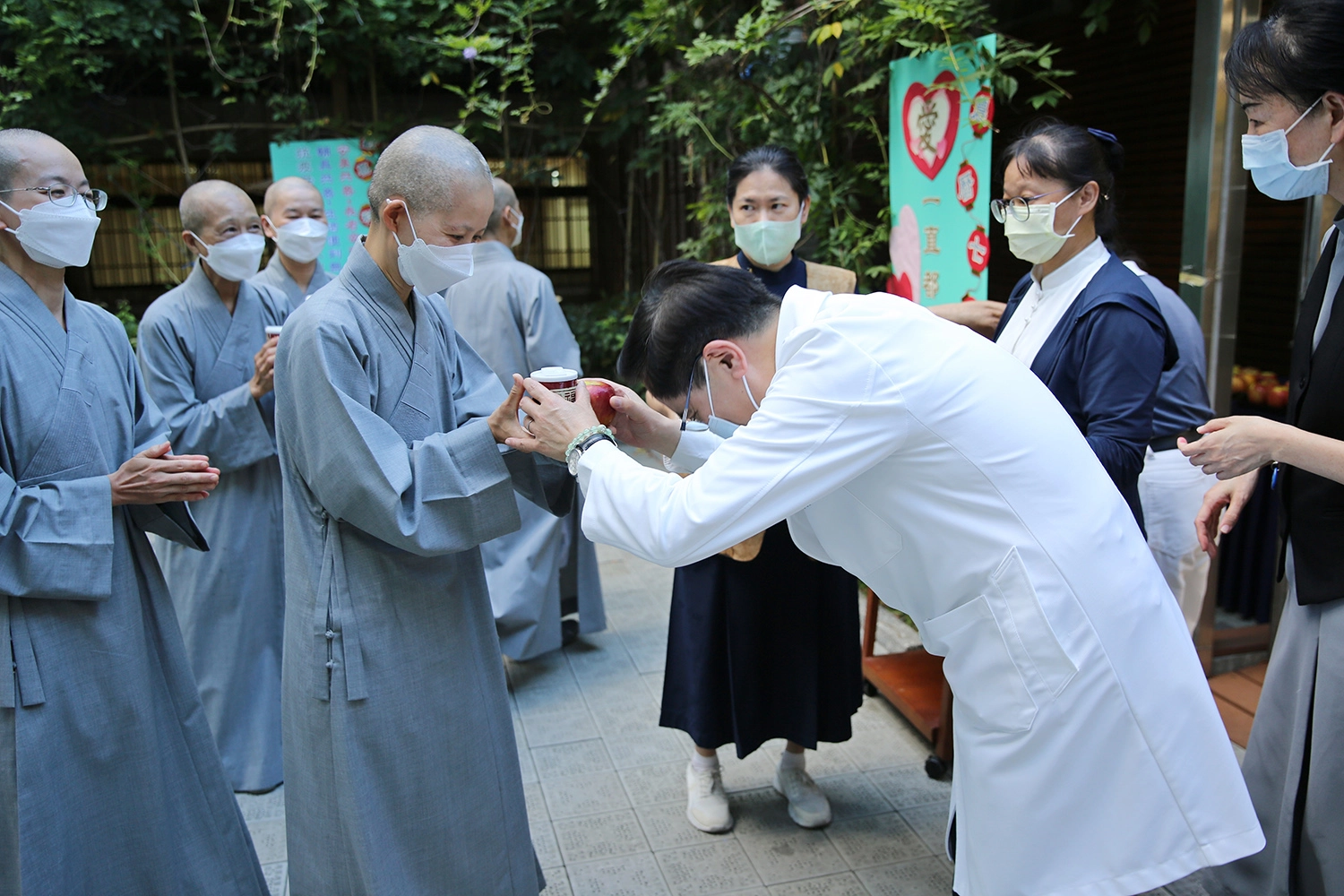 林欣榮院長於會後發送福慧粥、蘋果與會眾結緣,特別感恩精舍師父帶領祈福會。(江家瑜攝)