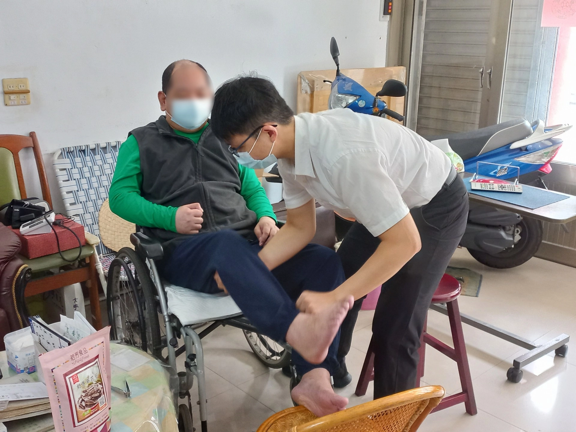 周仁傑醫師(右)關心中風鄉親肢體狀況。