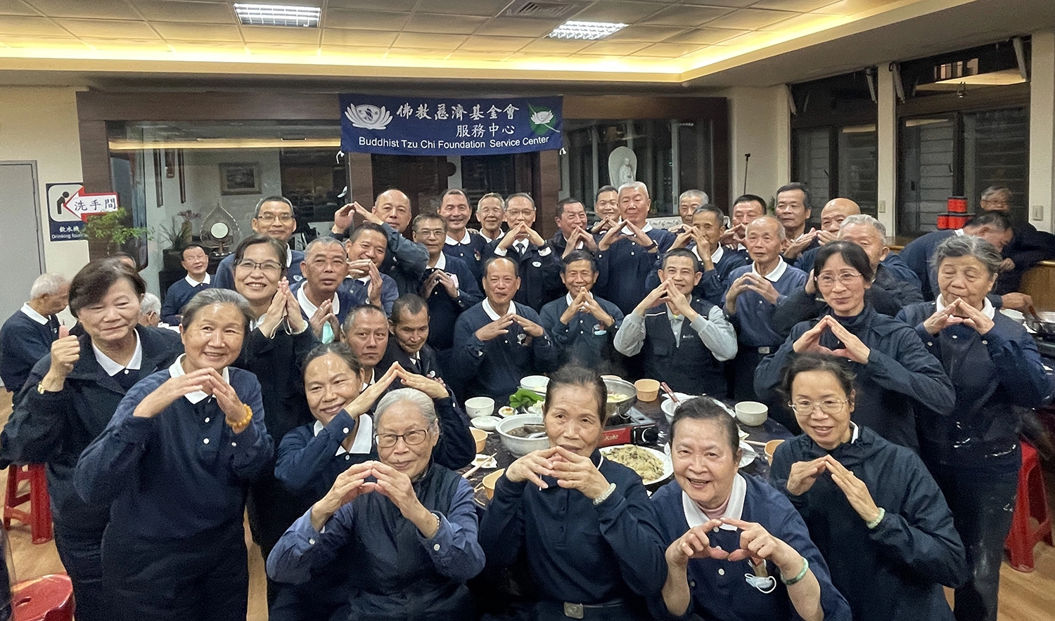 冬至夜晚,慈濟邀請慈濟修繕志工到玉里靜思堂圍爐,大家一起比「家」手語期許為鄉親打照安全的家。(攝影:葉宜家)