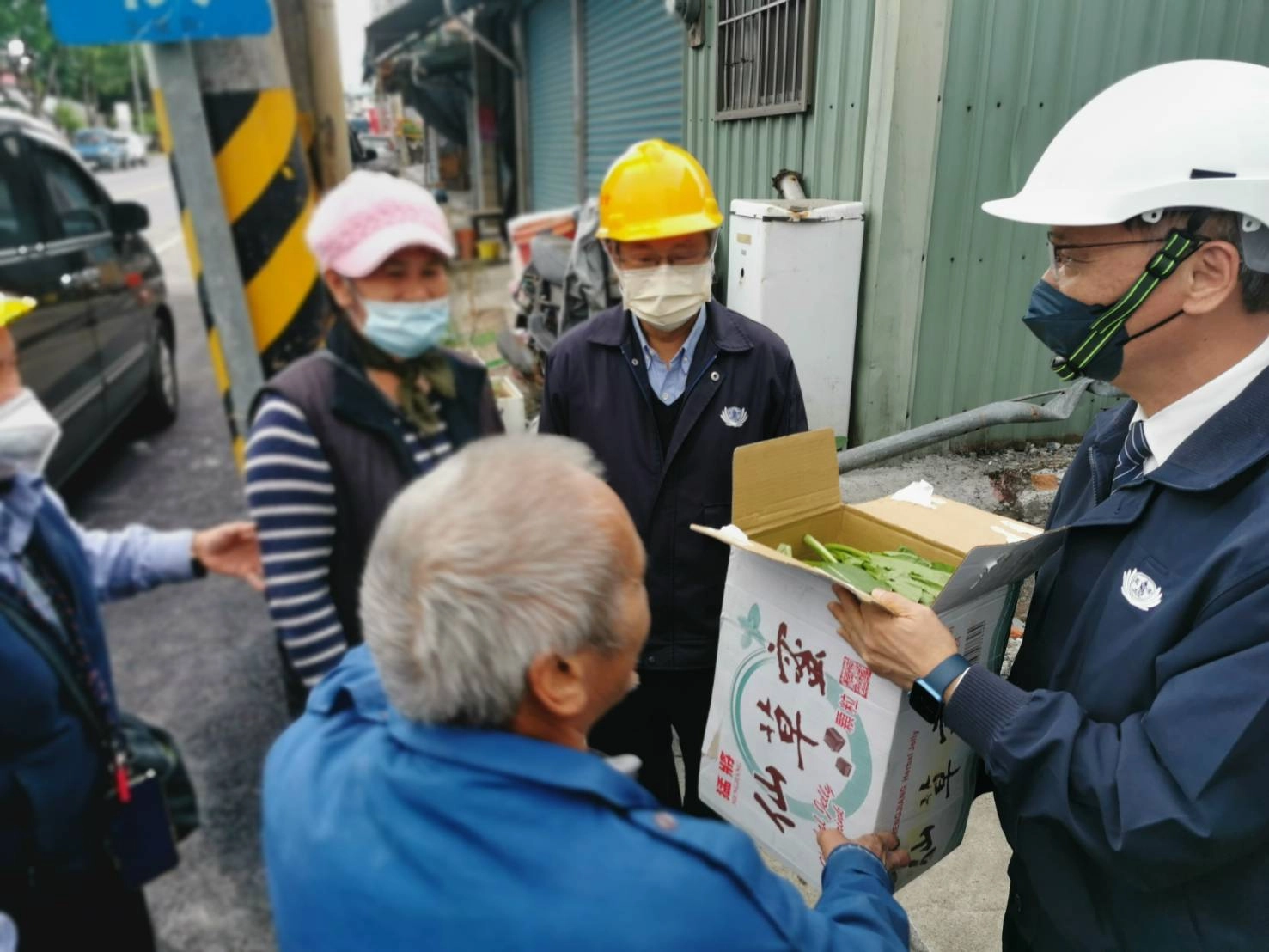 張女士在冬至這天聽聞慈濟要來了解重建進度,親手摘了一箱油菜請鄰居幫忙送給慈濟。(攝影:陳祖淞)