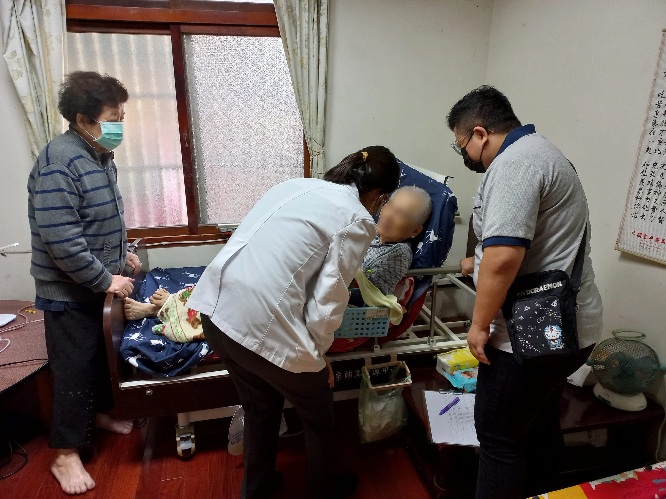 莊孟臻醫師(左)親切問候臥床長者。