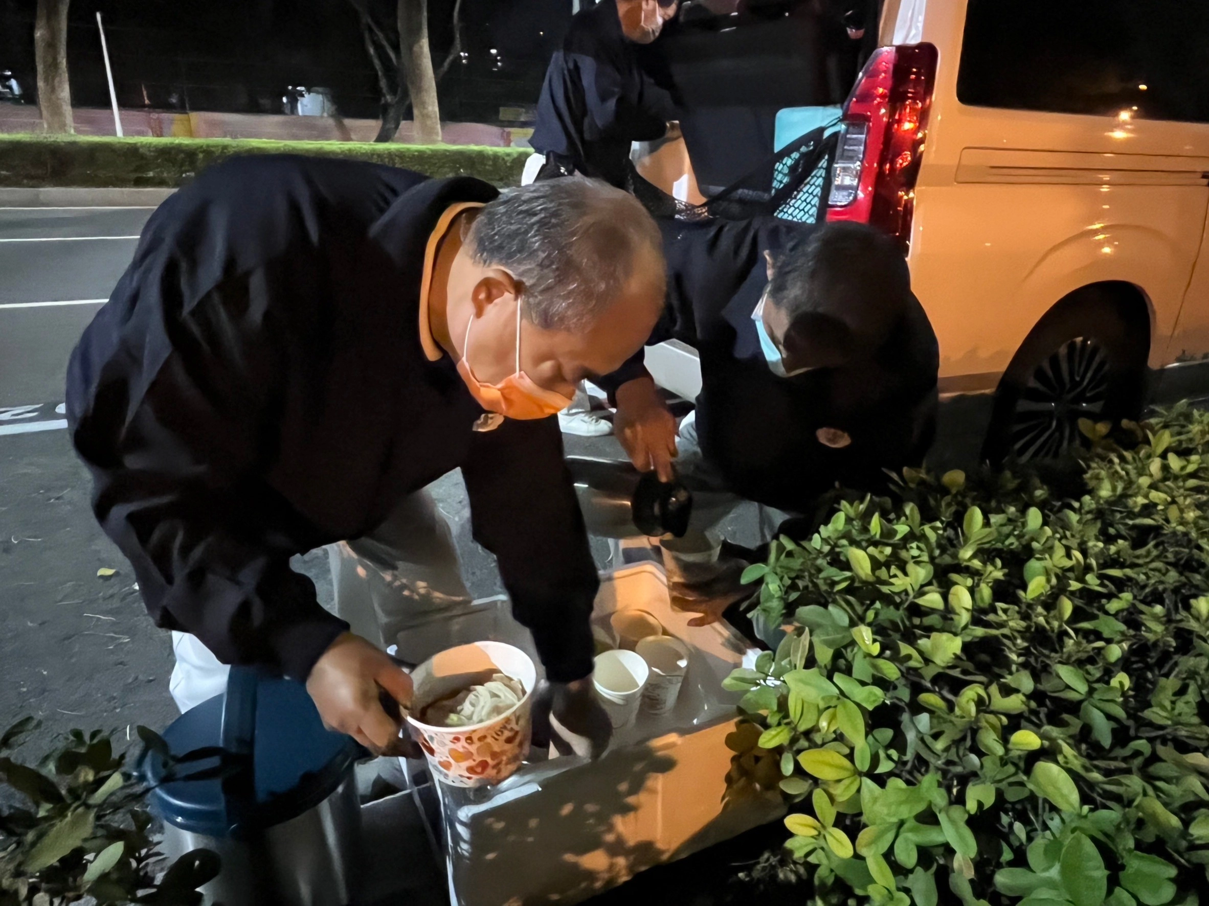 到達關懷定點後,慈濟志工將熱熱的藥膳補湯裝進碗中並分送給街友。