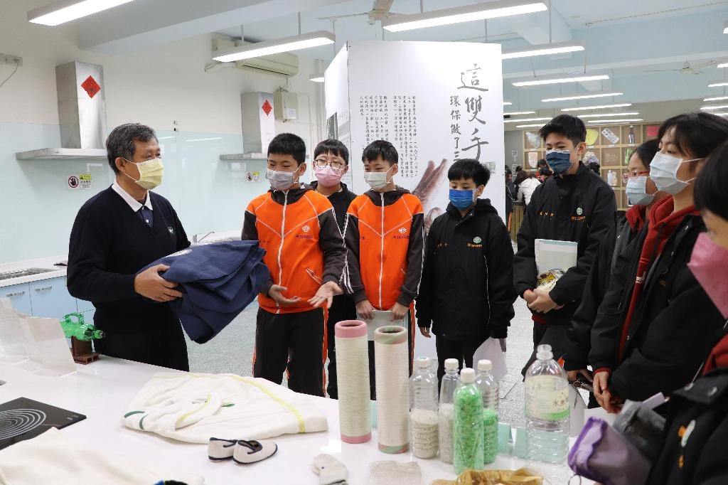 資深環保幹事黃文川向同學解說寶特瓶回收再製成的產品。