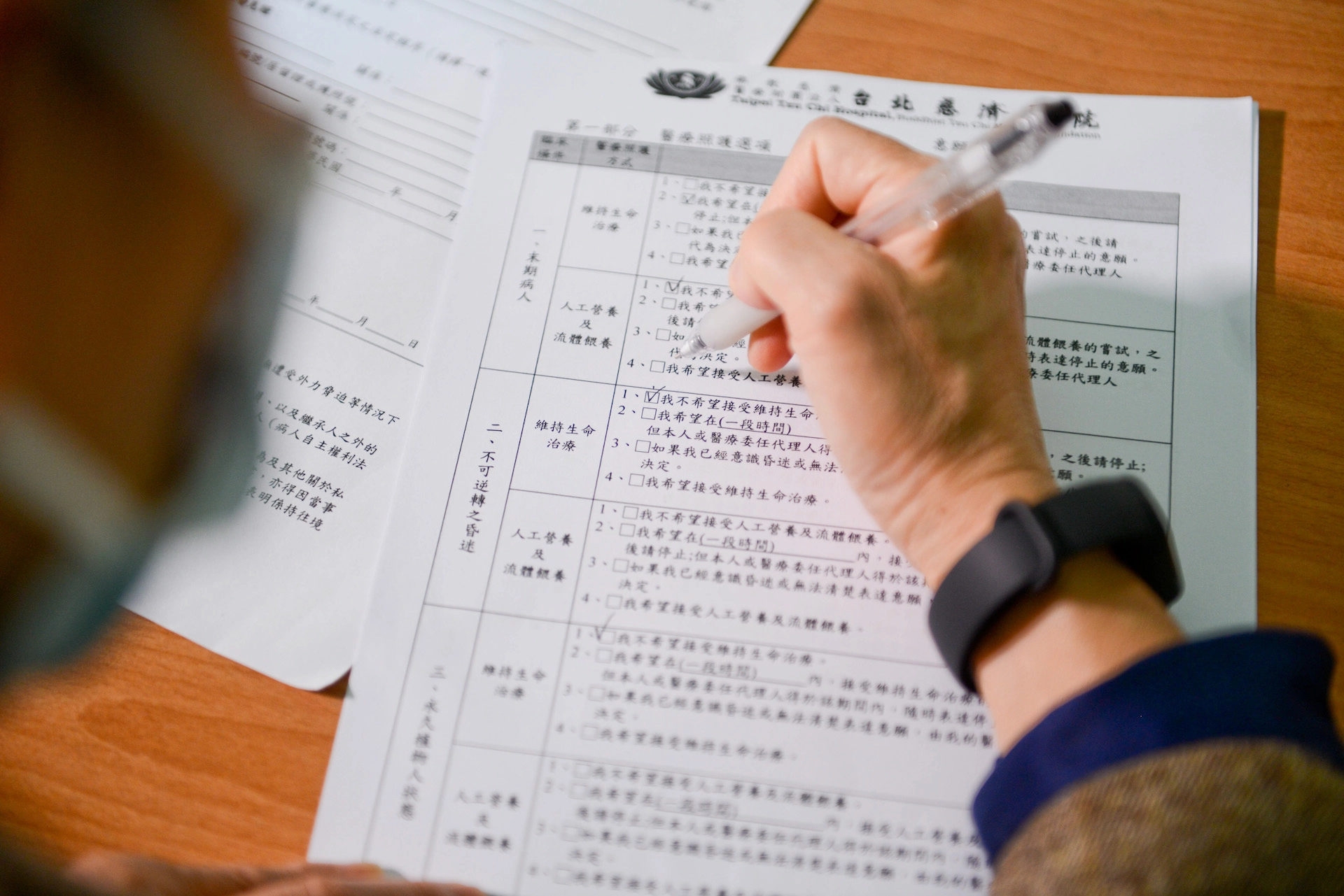 意願人與家人討論後,在預立醫療決定書上勾選自己期待的醫療選擇。