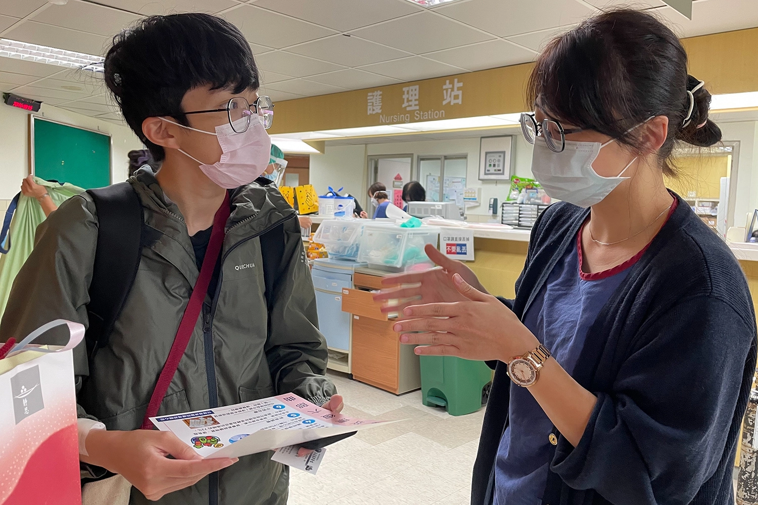 專責病房護理長周云鵑(右)送上證嚴法師與醫院為確診康復病人準備的祝福禮,向恢復良好的許律(左)道喜外,也仔細叮嚀她出院後的注意事項。