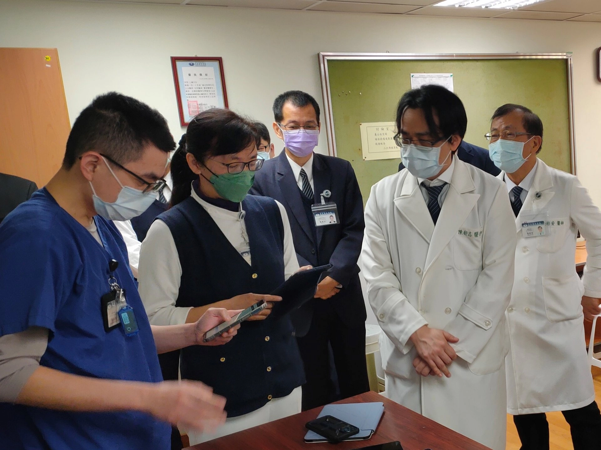 「智慧式全方位行動巡房APP」讓臨床醫師、護理師可以隨時隨地查閱病人資訊（包含生命徵象，重要臨床生理數值，檢驗數據，清晰的影像，心電圖等），對於教學、解釋病情也極為方便。圖中為副院長吳彬安(後排右一)、心臟內科主任陳郁志醫師(前排右一)、人工智慧醫療創新發展中心副主任陳靈均(後排右二)。
