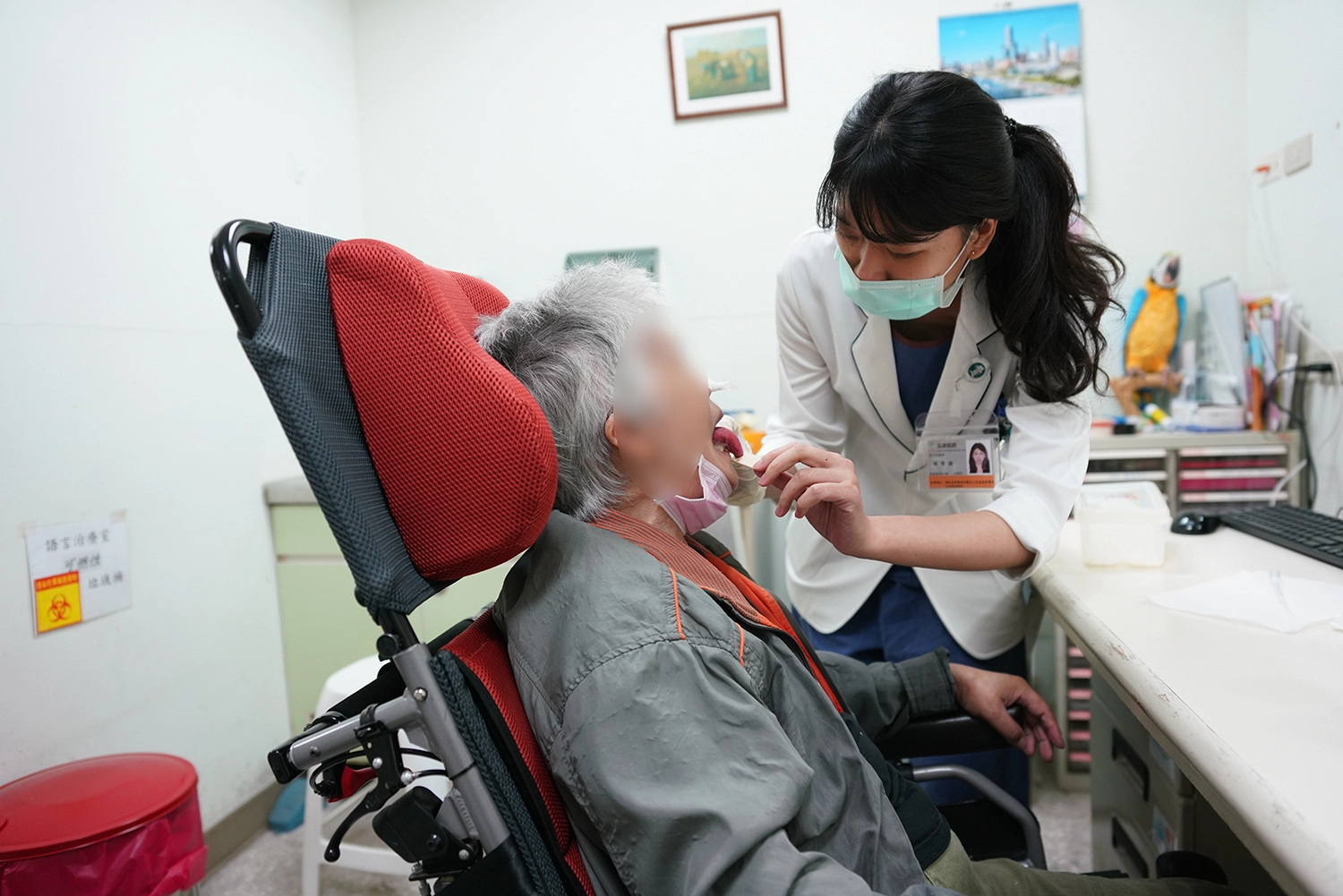 語言治療師林佳瑜利用壓舌板引導病人做舌頭抗阻力運動,訓練其舌頭上抬之肌肉力量。