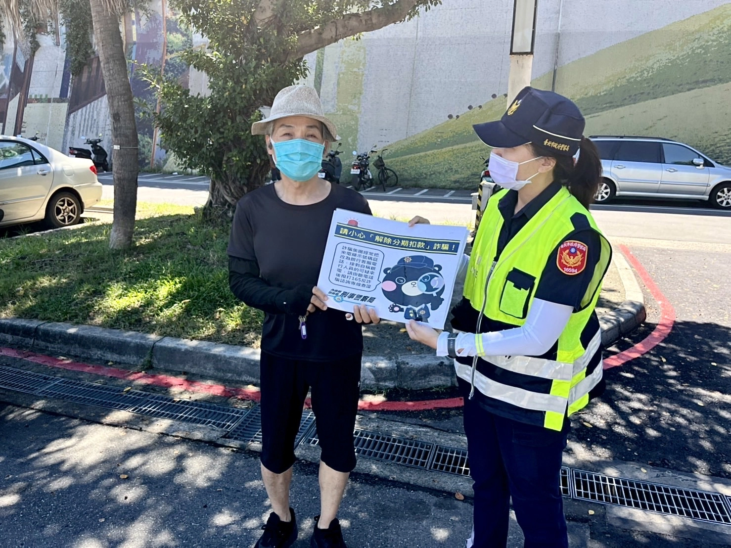 保大警手持宣傳標語,提醒民眾常見的網路詐騙手法。