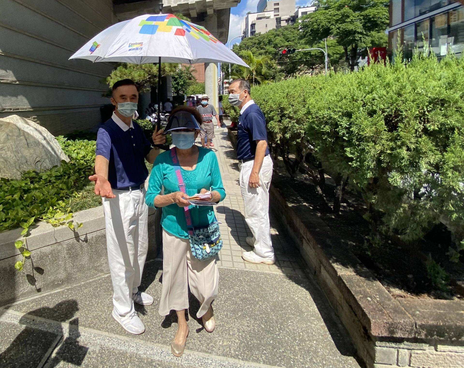 臺中志工關懷施打疫苗長者,貼心的沿途為長者撐傘防曬。