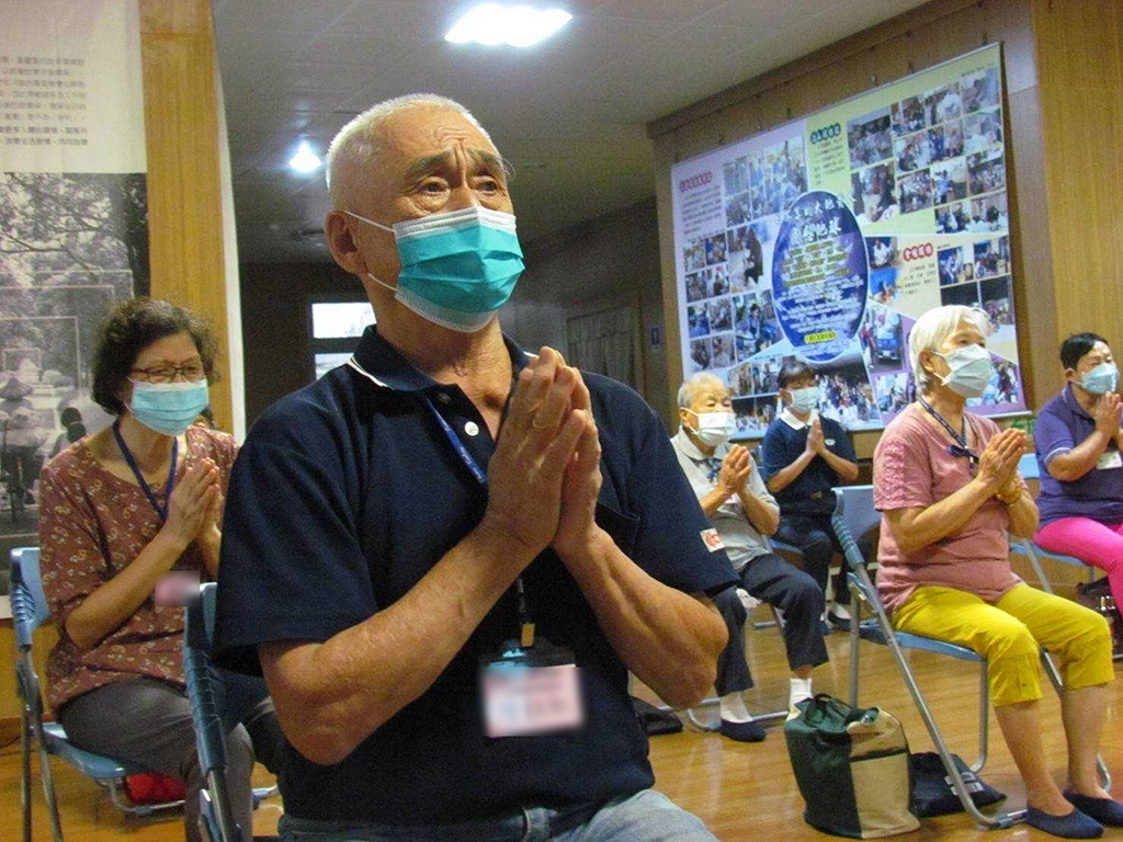 長輩們雙手合十,神情肅穆,祈願善念共振消弭戰爭,世界和平。