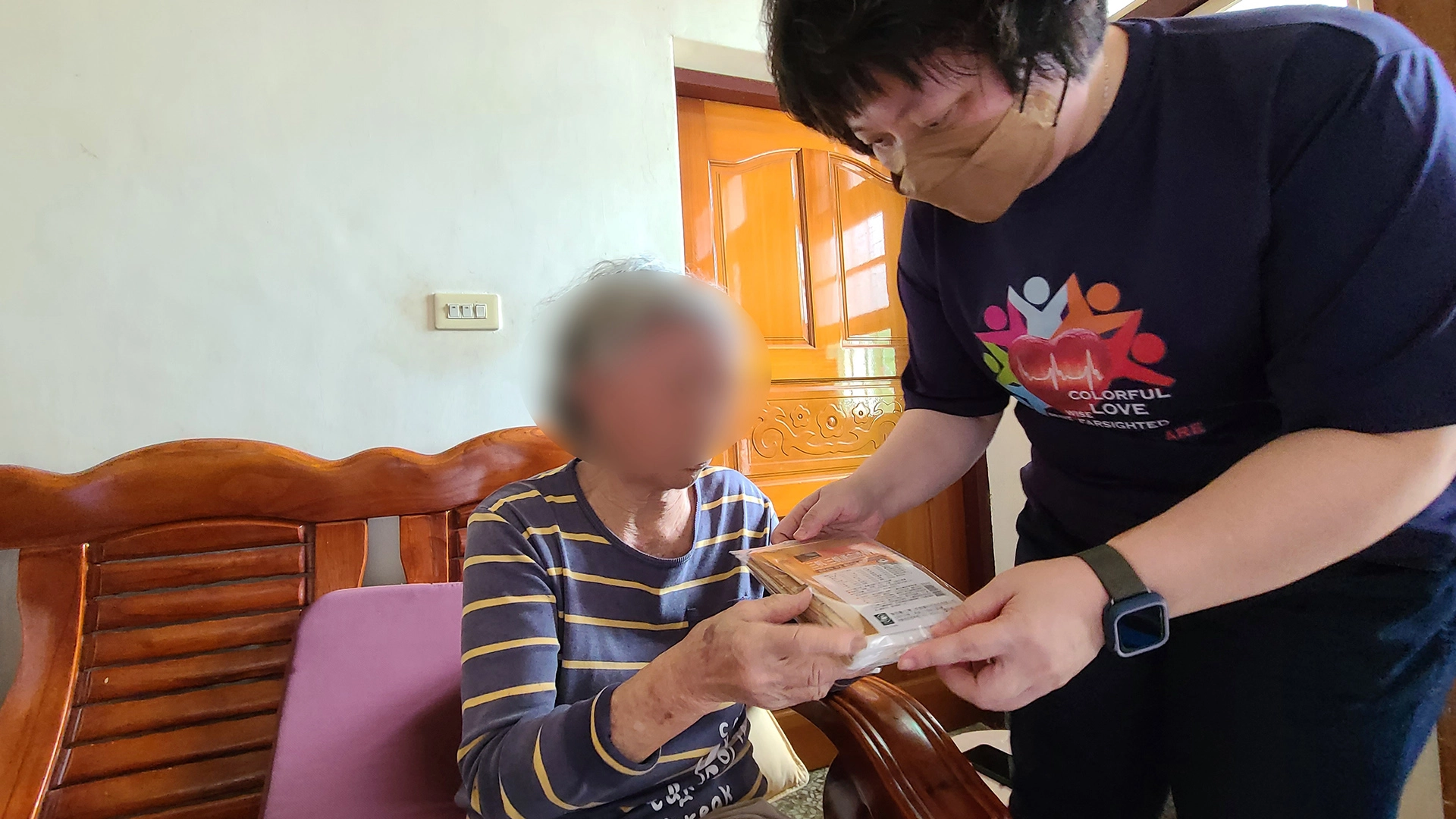 社服室主任謝侑書(右)與團隊往診時,帶上酸痛貼布來跟阿嬤結緣,緩解阿嬤肌肉酸痛的不適。