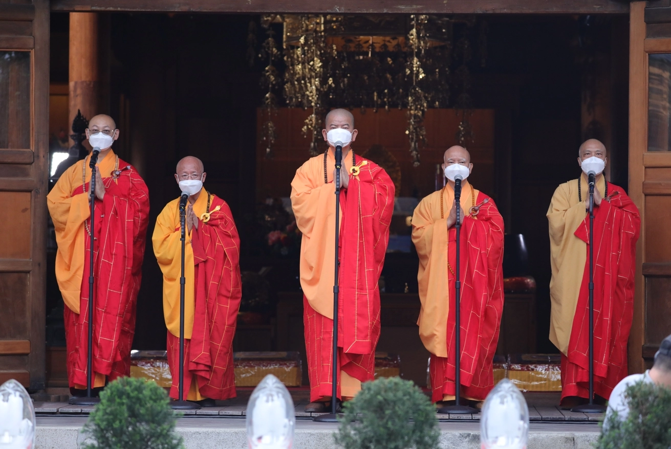 位於臺北臨濟護國禪寺浴佛現場的明光法師(中)、厚賢法師(左二)、悟禪法師(右二)、悟豪法師(右一)、自定法師(左二)五位長老法師，帶領大中齊聲念誦祈福文。
