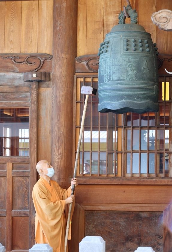 明宗法師敲響祈福和平鐘，祈願疫情與殘酷的戰爭，能早日消弭。