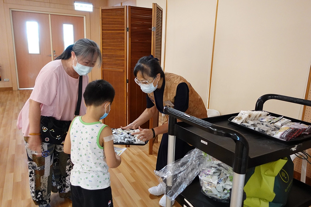慈濟志工準備餅乾點心,讓小朋友不害怕來打針。