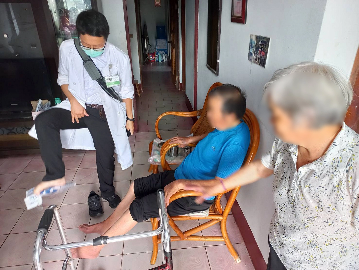 鄭主任向往診鄉親示範用腳掌夾紙,輔助平衡減少跌倒的風險。