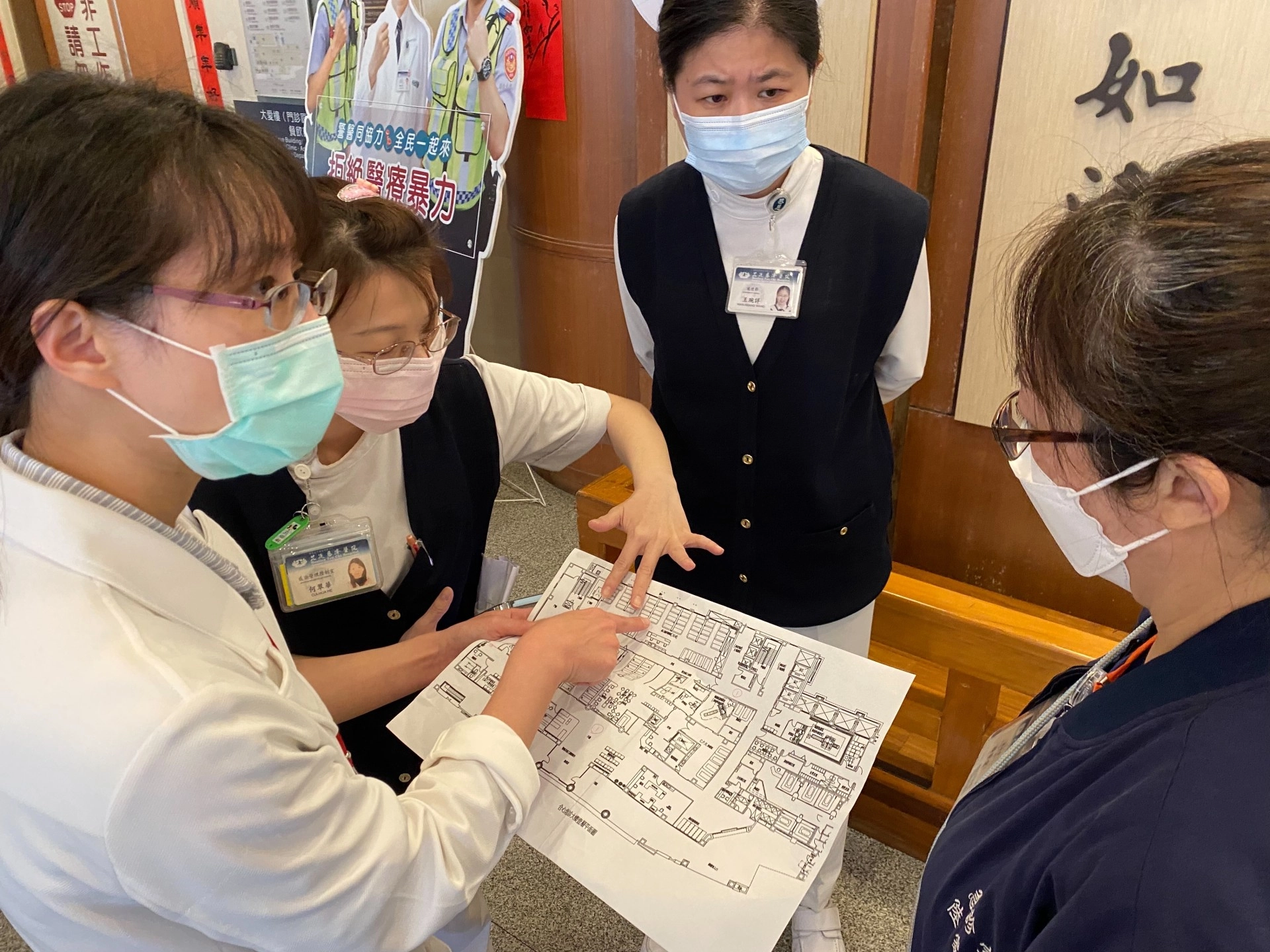 感管室主任黃妙慧醫師(左一)、感控護理師何翠華(左二)與急診室護理長陸家宜(右一)確認病床空間配置圖,右二為護理部副主任王琬詳。