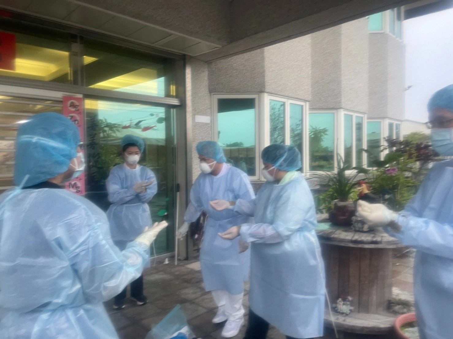 感管室黃妙慧主任(藍色工作服)、江惠莉組長(藍色工作服)、內科部副主任王智賢(後排右二)、老年醫學科主任高聖倫(後排右一)與社區健康中心護理師去安養中心做篩檢。