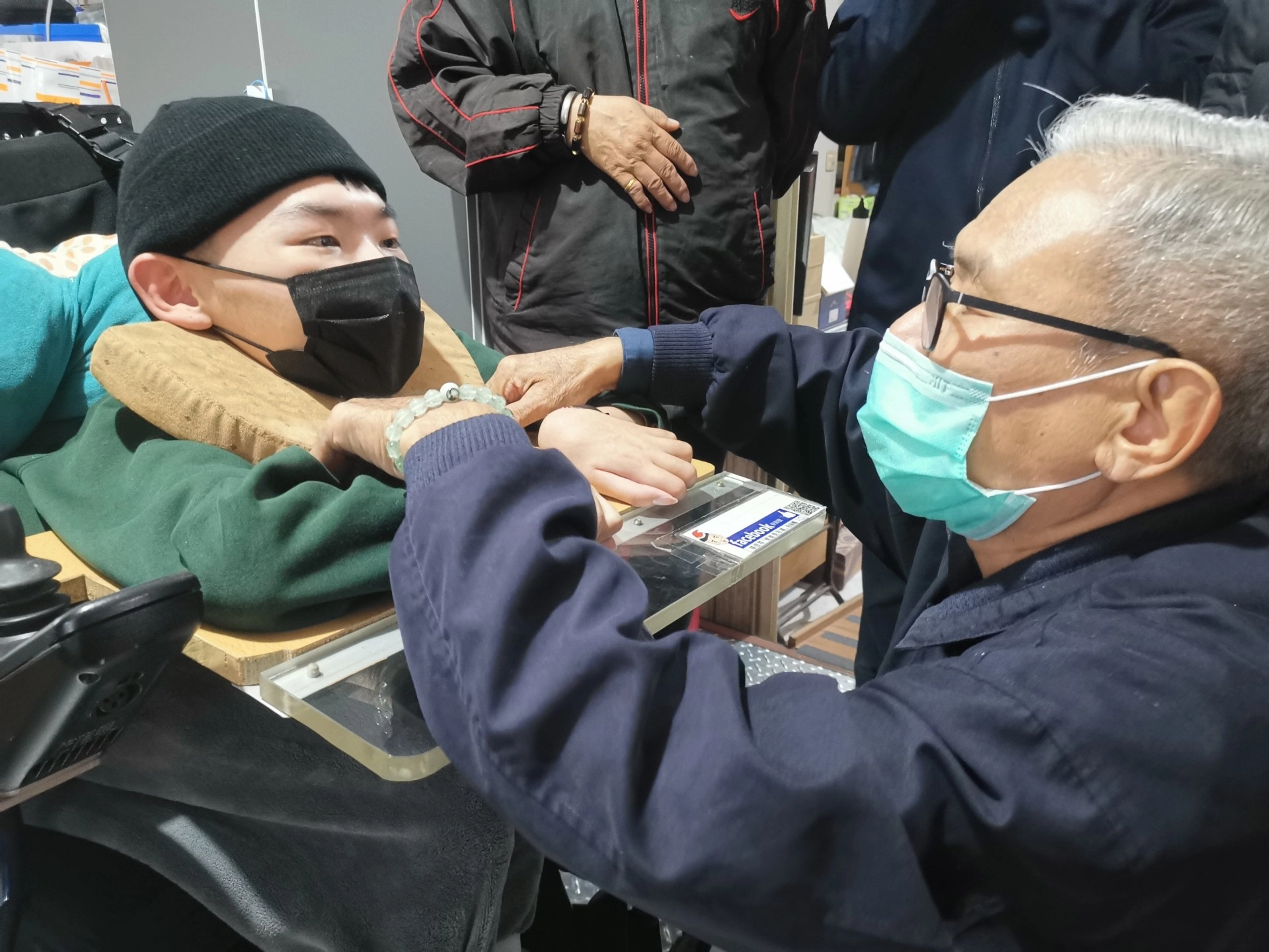 慈濟志工吳宏泰(右)為陳景維(左)量身打造U型枕頭,讓他外出在車上也能看到窗外風景。