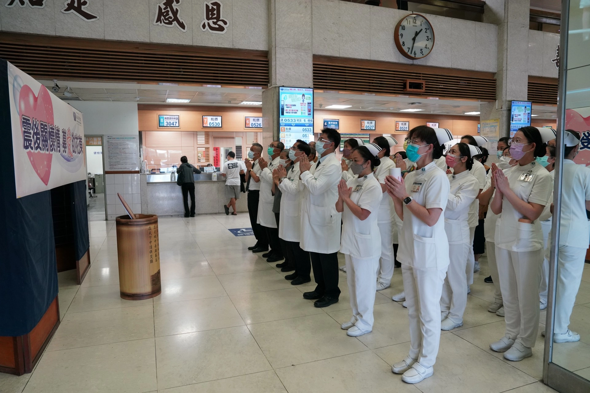 十月三日下午,花蓮慈院啟動募心募愛活動,院長林欣榮(前排右三)等多位主管帶領同仁及醫療志工,在門診大廳佛陀問病圖前,合十唱頌「祈禱」祈福。