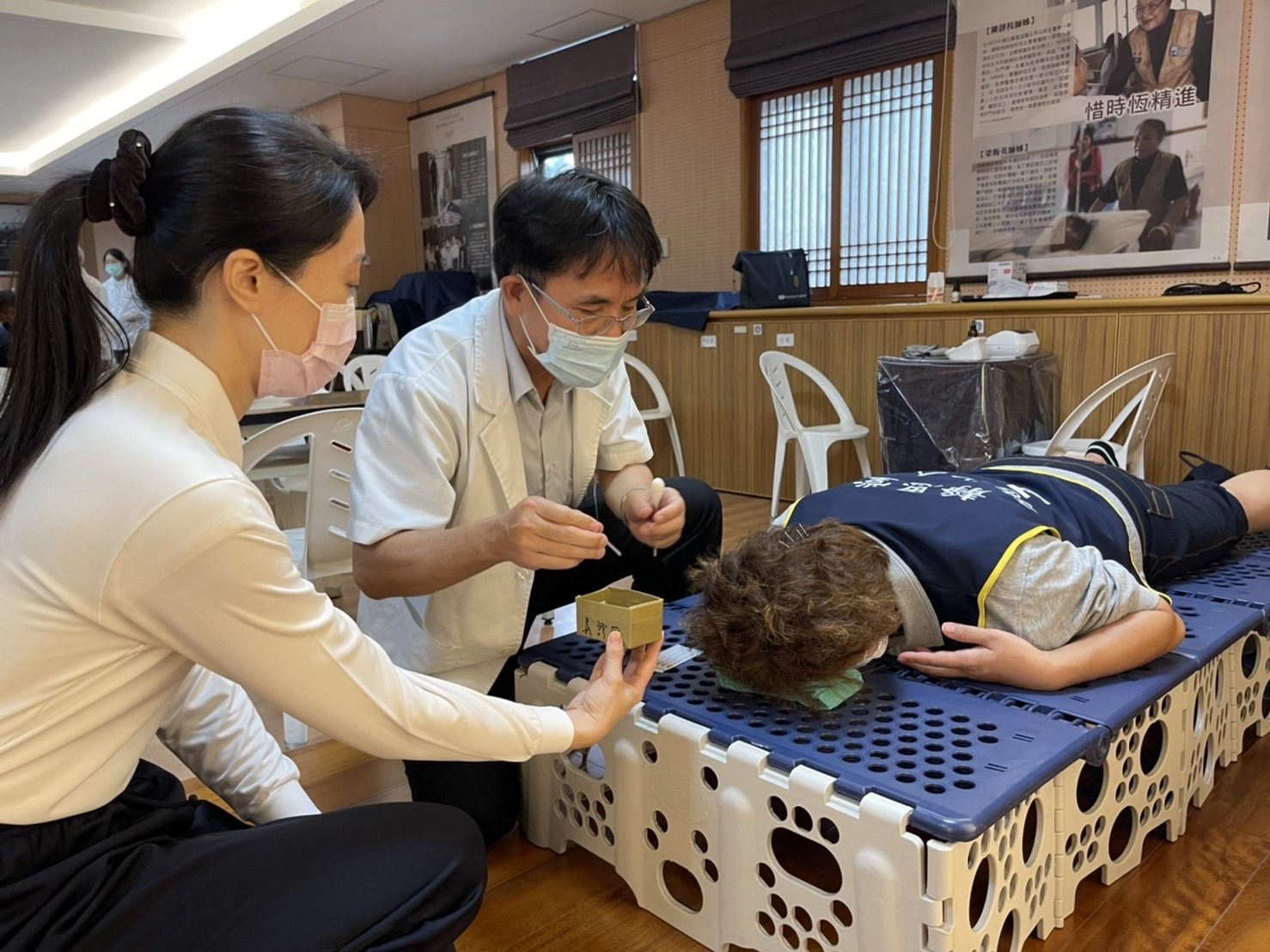 花蓮縣中醫師公會理事長黃輝榮(圖左二)以針灸緩解志工連日的肌肉痠痛及頭痛。