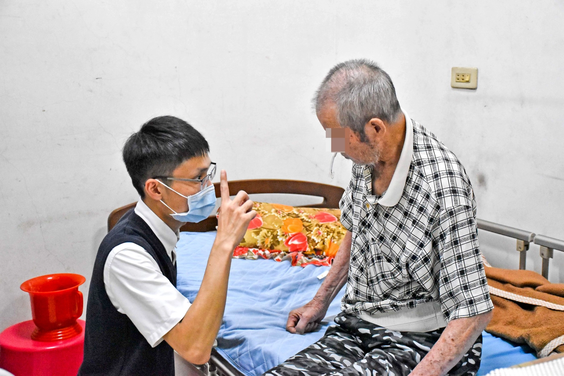 物理治療師潘建志到府指導王爸爸復健訓練。