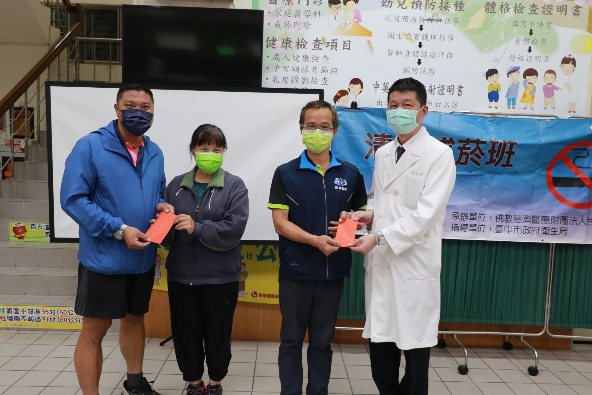陳慶元主任(右一)頒獎給戒菸成功的高先生;林瑞文里長(左一)加碼感謝高太太的支持。