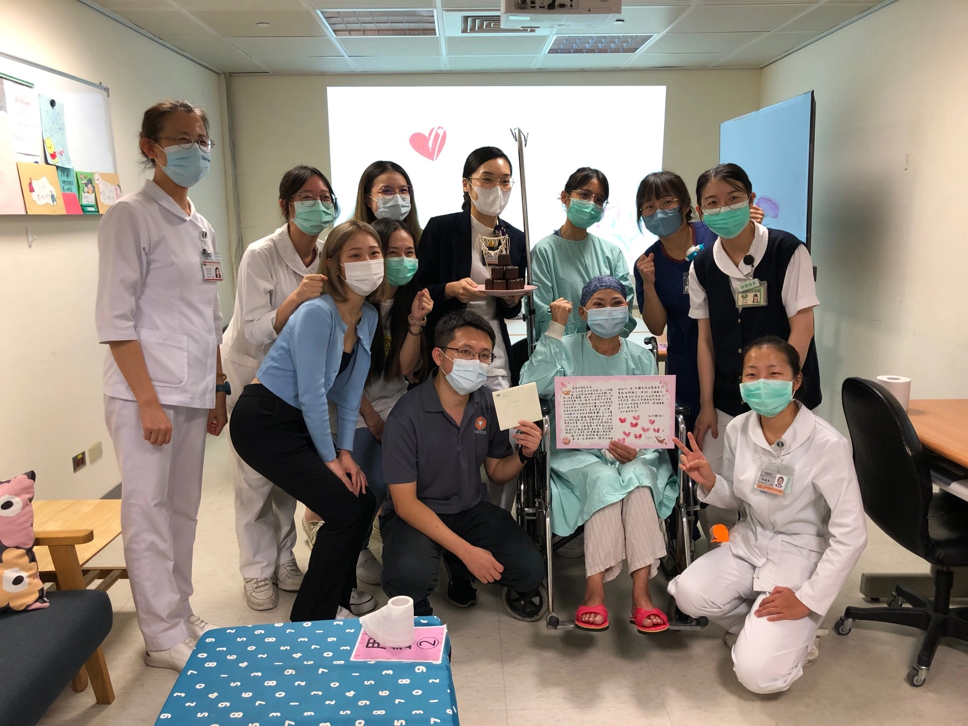 賴女士生命重生,兒子(中)陪伴在旁,他們與骨髓移植病房團隊與合影留念。