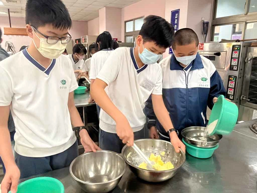 食品群的同學專注於攪拌,體會到餅乾製作真不簡單。