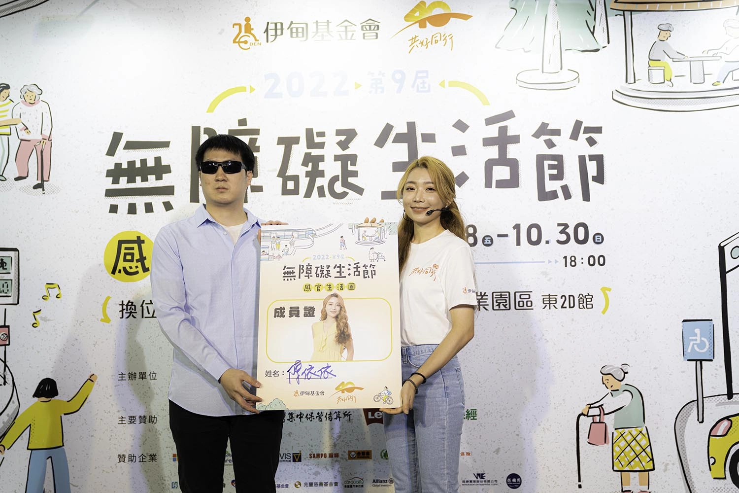在公益大使依依完成所有挑戰關卡後,由視障代表彥仁頒發成員證,象徵依依成為推動無障礙生活的一份子。(伊甸基金會提供)